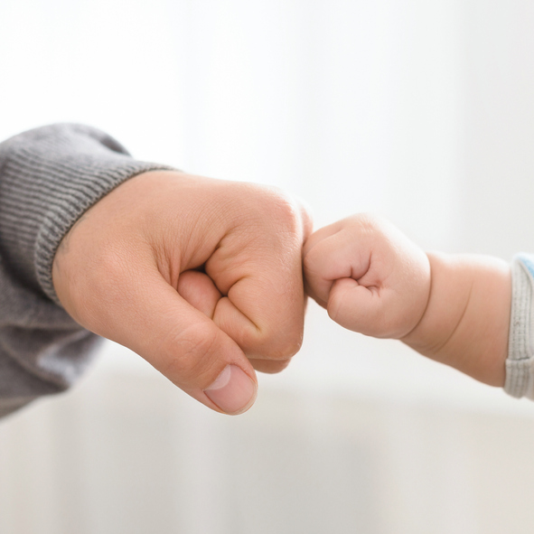 Close up of father holding baby hand